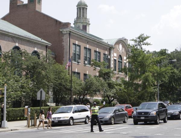 Students and parents crossing West 256 St. and Riverdale Ave. near PS 81 in Bronx, NY with the assistance of a crossguard